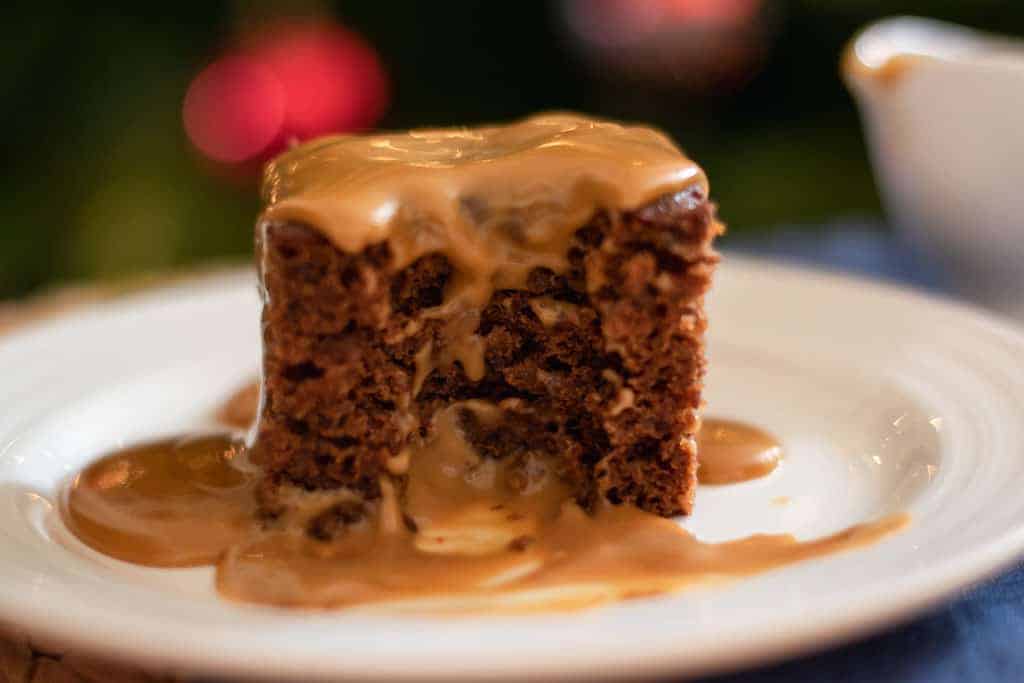 a slice of sticky date pudding served with toffee sauce