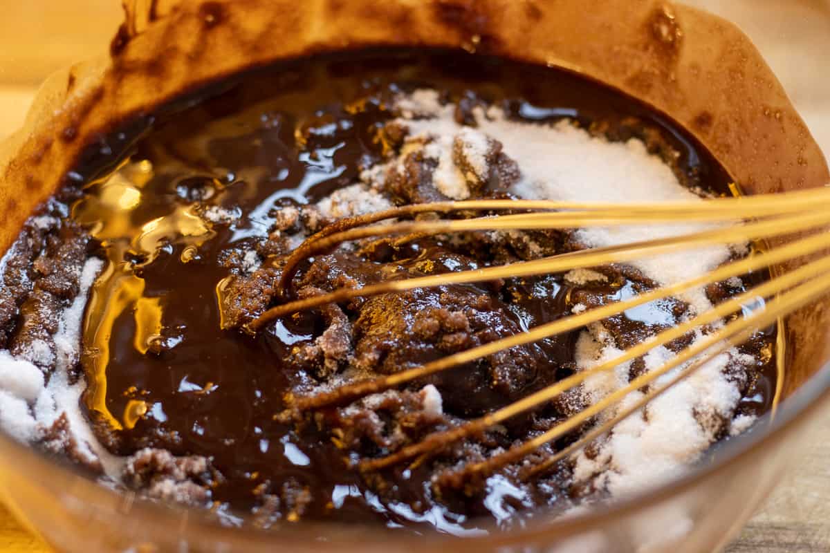 adding the sugar in melted chocolate and butter