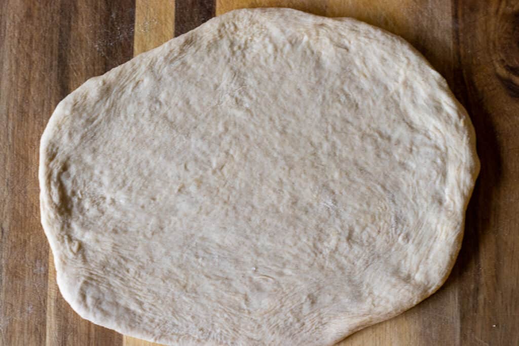 A dough ball is shaped into a circle.