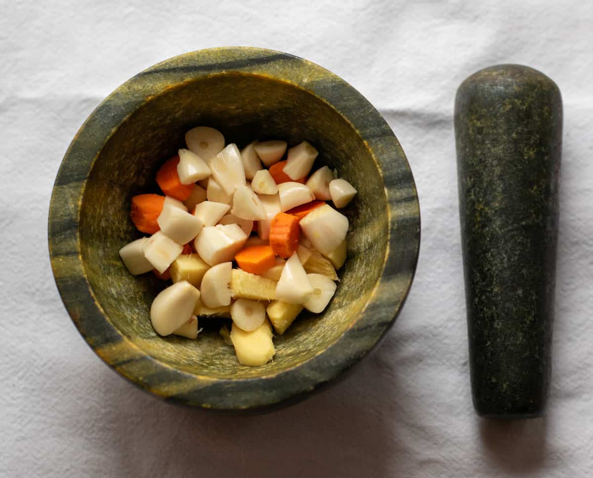 ginger, garlic and turmeric are in a mortar