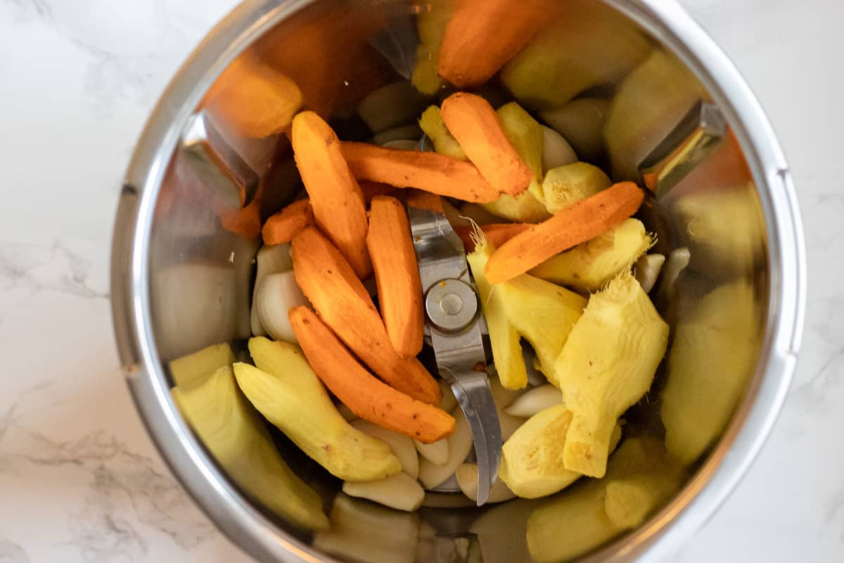 ginger, garlic and turmeric are placed in a jag of a food processor