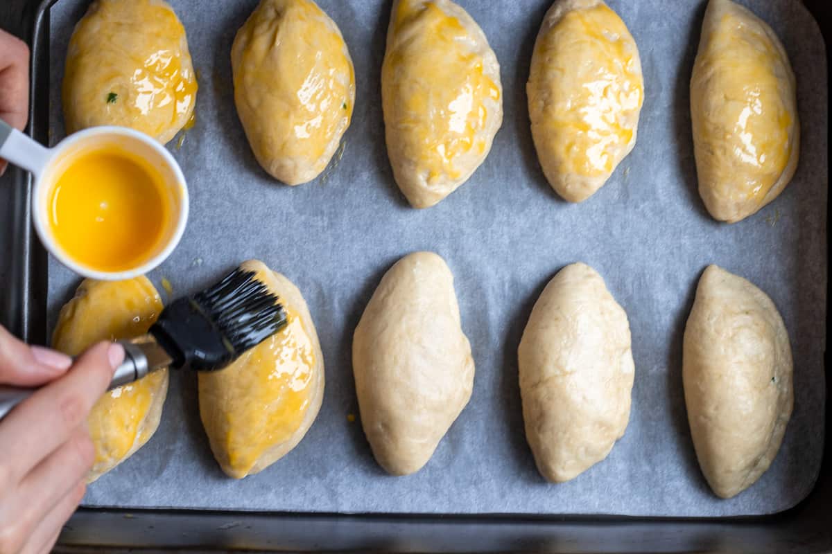 egg washing the pastries using a brush