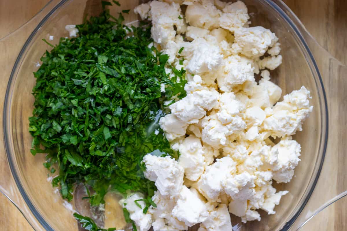 feta, egg white and herbs are put in a bowl for making pogaca filling