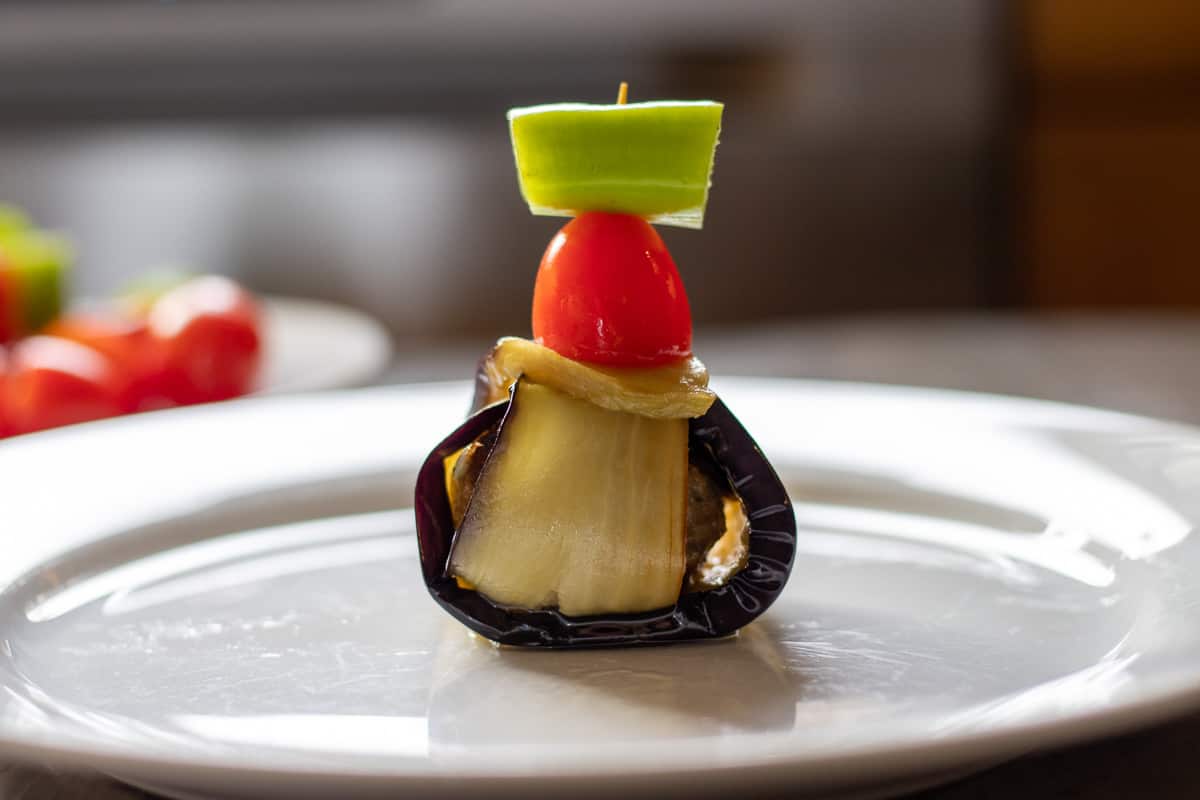meatball wrapped in aubergine is secured with a toothpick