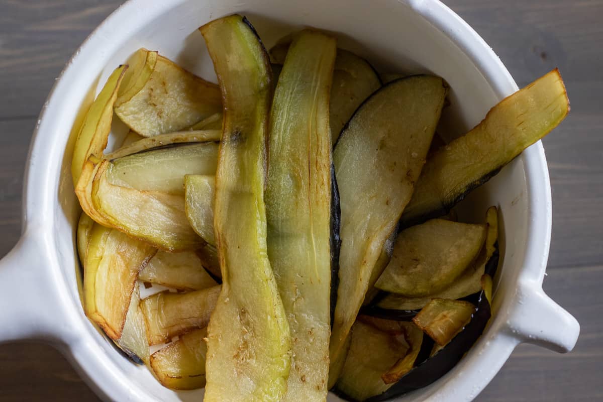 fried aubergine slices are placed on a colander