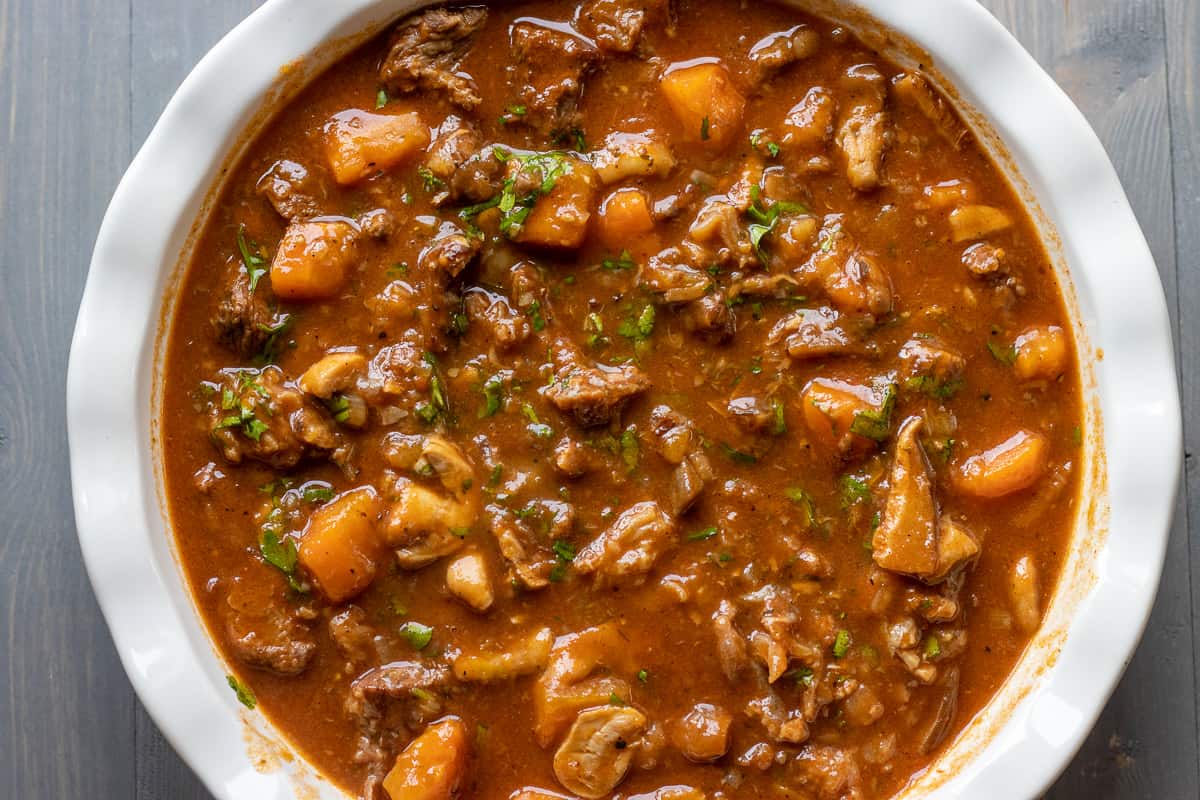 steak pie filling is transferred in a pie dish