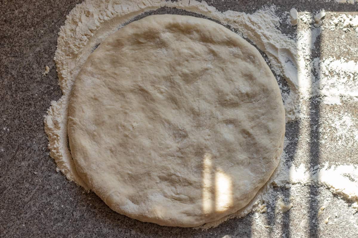 A dough ball is rolled into a circle.