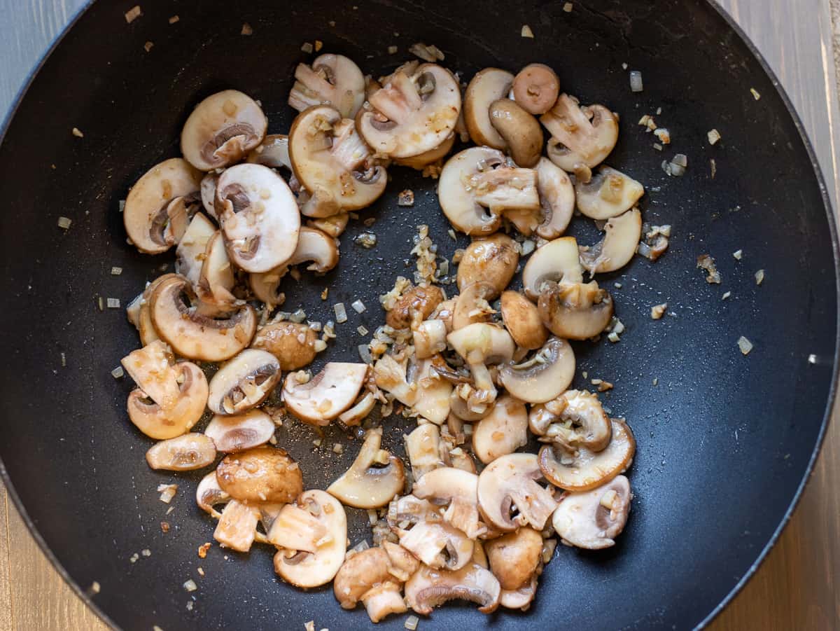 Sautéing the shallots and mushrooms in a pan