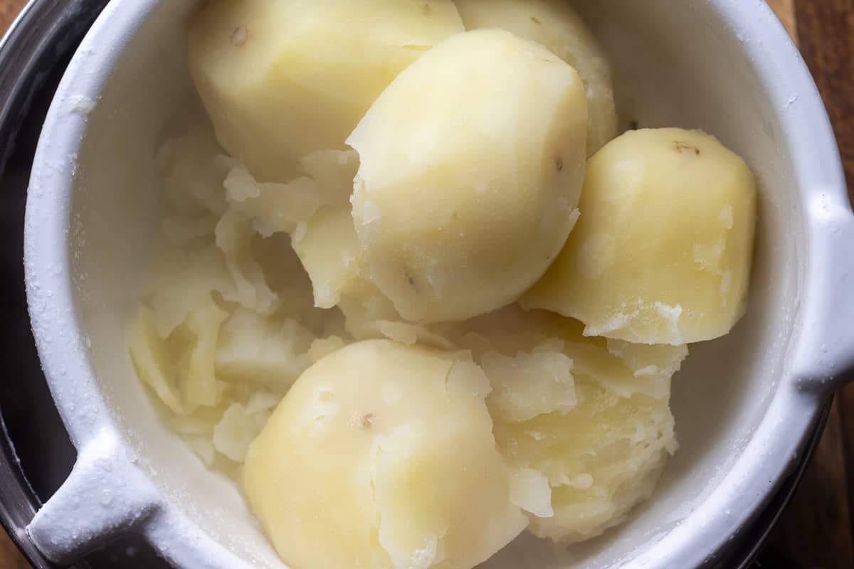 draining the cooked potatoes on a colander