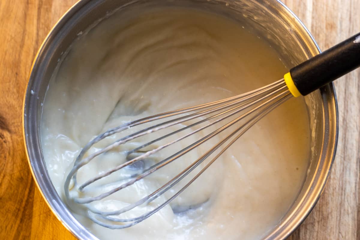 Adding the milk gradually to make bechamel