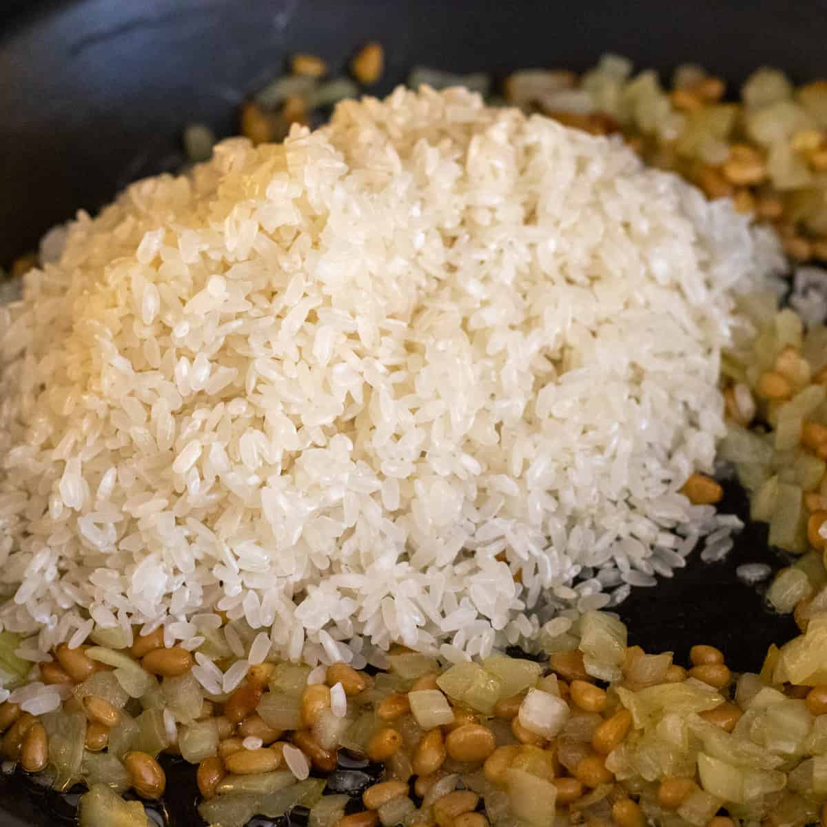 add rice to onions and pine nuts