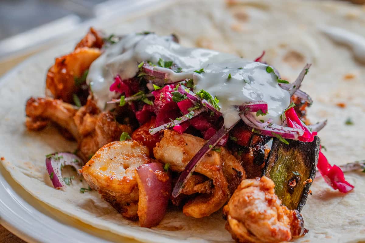 shish tarok served on pita bread with side salads