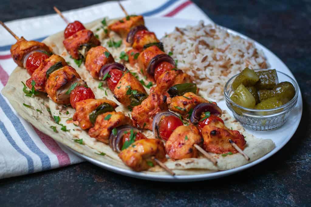 Shish tawook (Turkish Chicken Kebab) served with rice and mixed pickles.