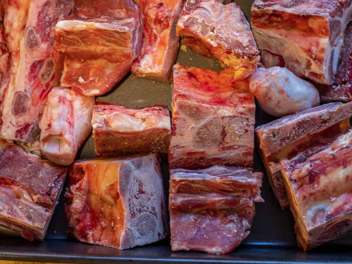 beef bones for homemade beef stock are placed on a tray for roasting