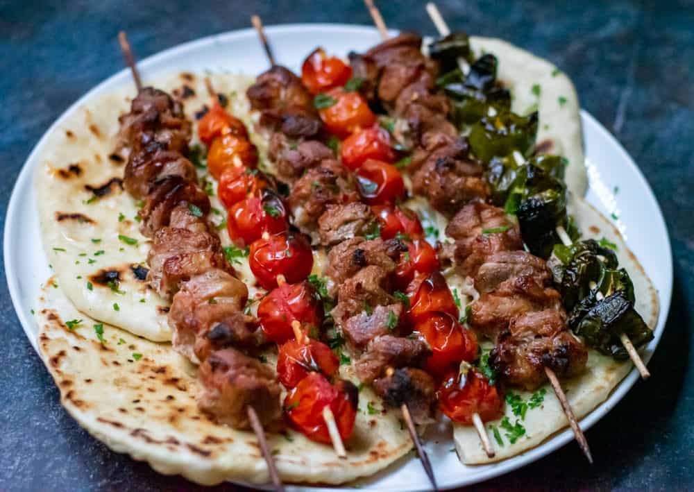 lamb shish kebabs served on top of pita bread
