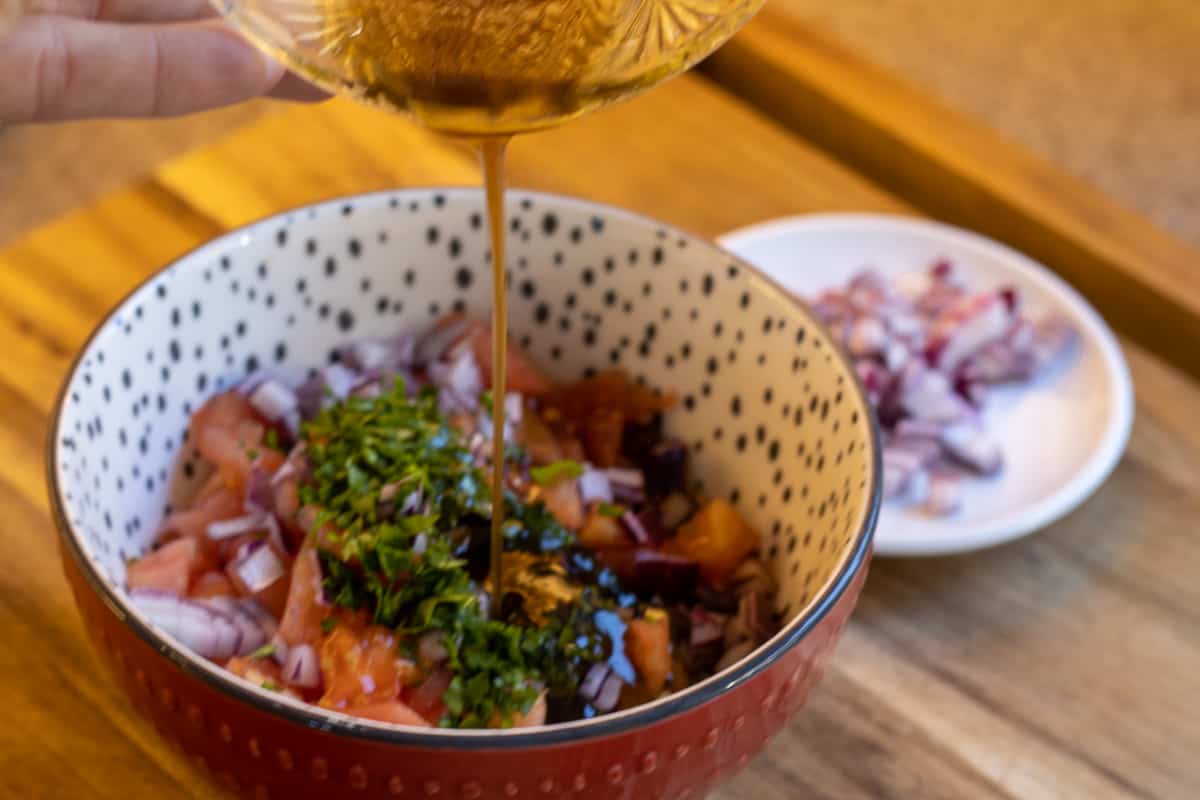 adding the dressing to the vegetables