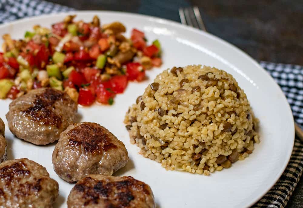 Turkish bulgur pilaf with lentils served as a side dish to inegol Kofte