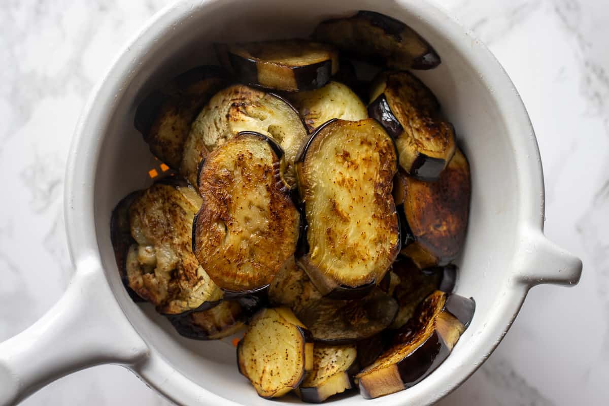 eggplants are fried and let to drain on a colander
