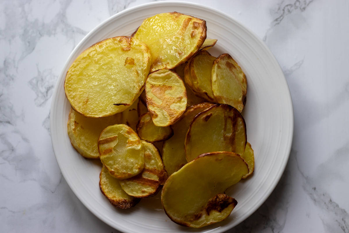 sliced potatoes are fried until lightly browned
