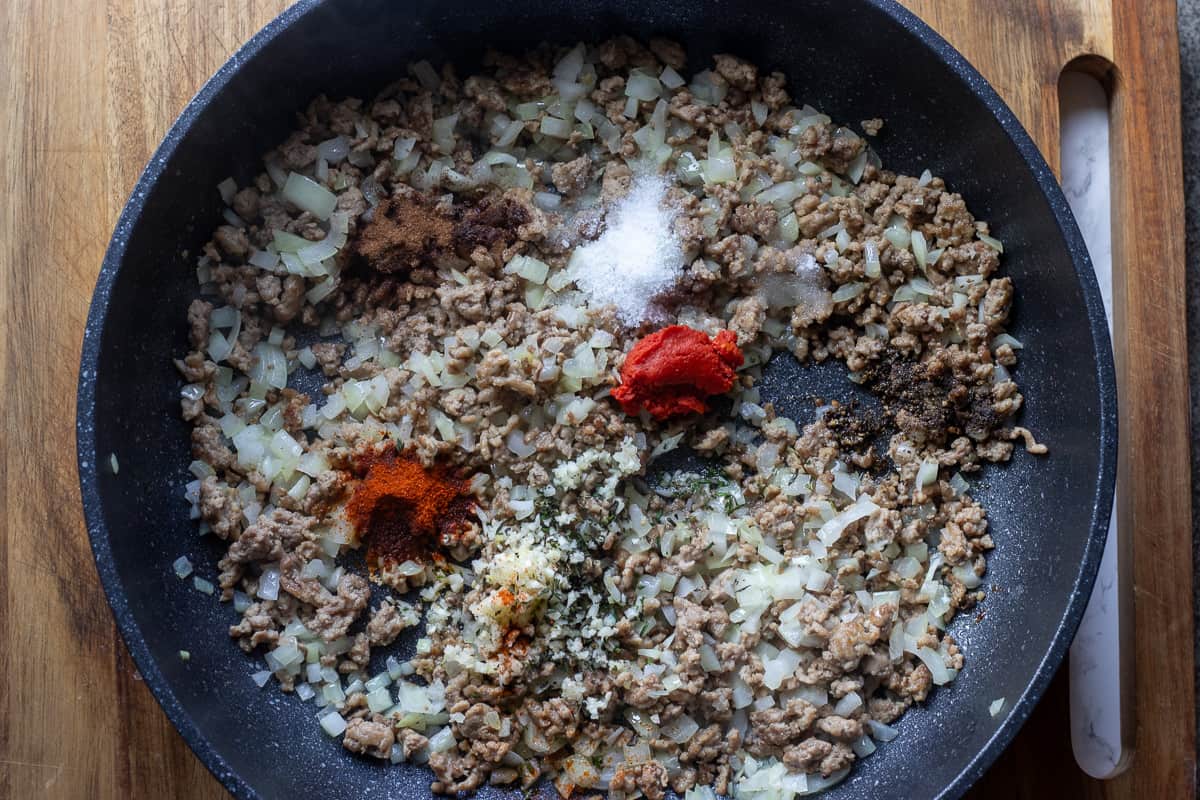 onions are sautéed in a pan before adding the spices and tomato paste