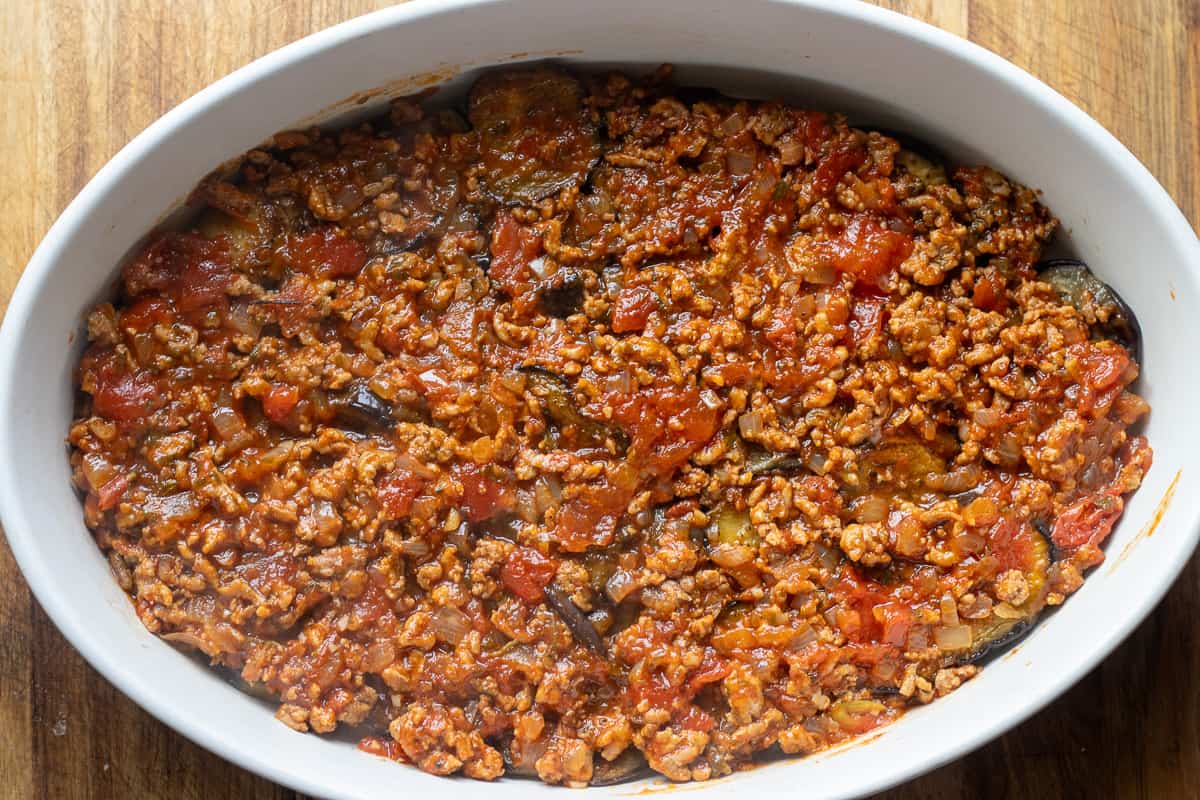 half of the meat filling is layered on top of eggplants