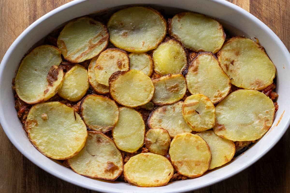 potatoes are layered on top of the meat filling