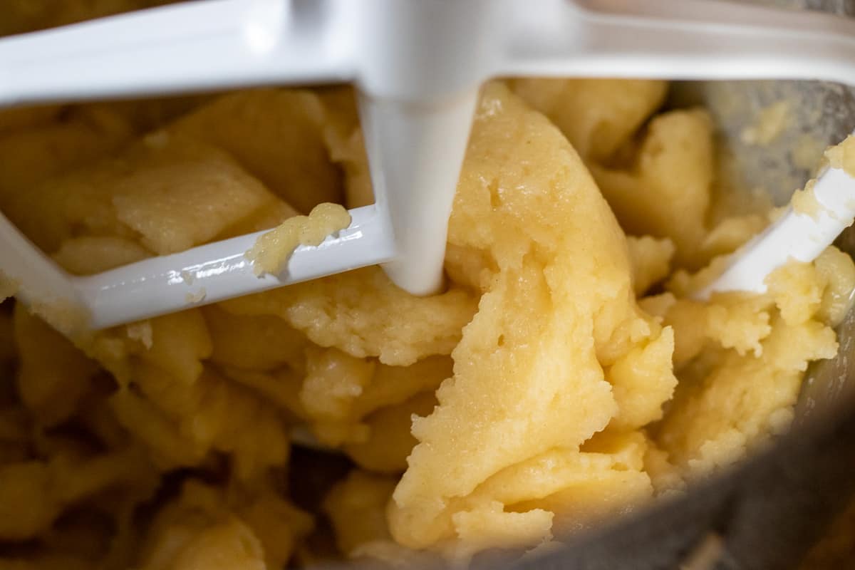 adding the eggs into dough using a mixer