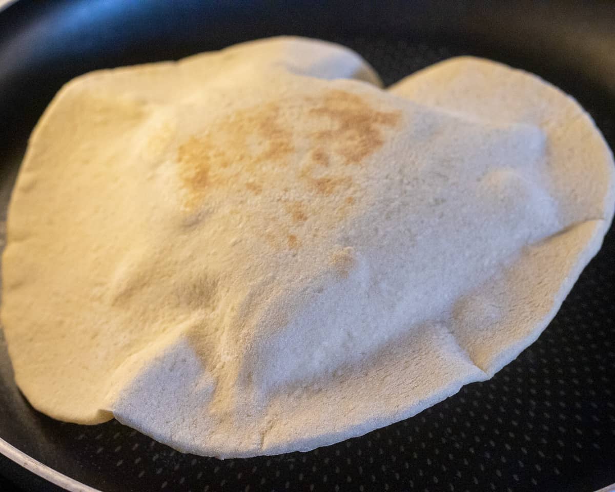 Cooking pita bread on a hot pan.