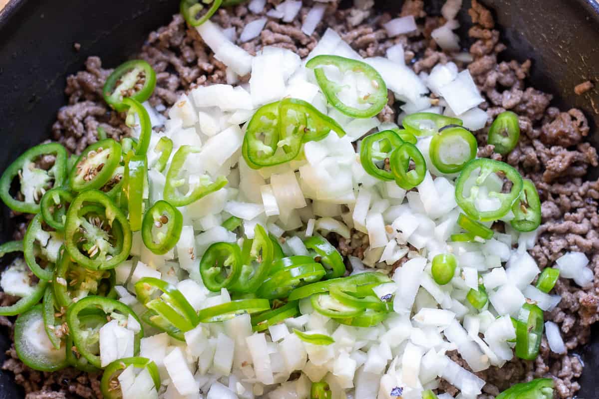 onions and peppers are added to mince