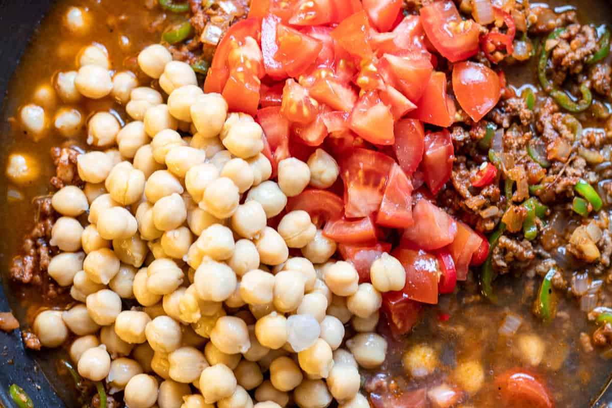chickpeas, stock and tomatoes are added to the pan