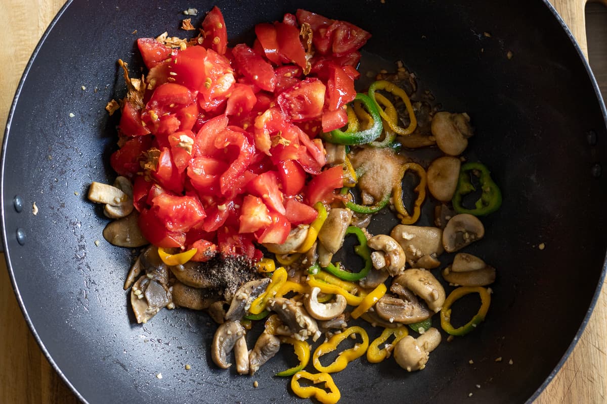 garlic and tomatoes are added to the pan