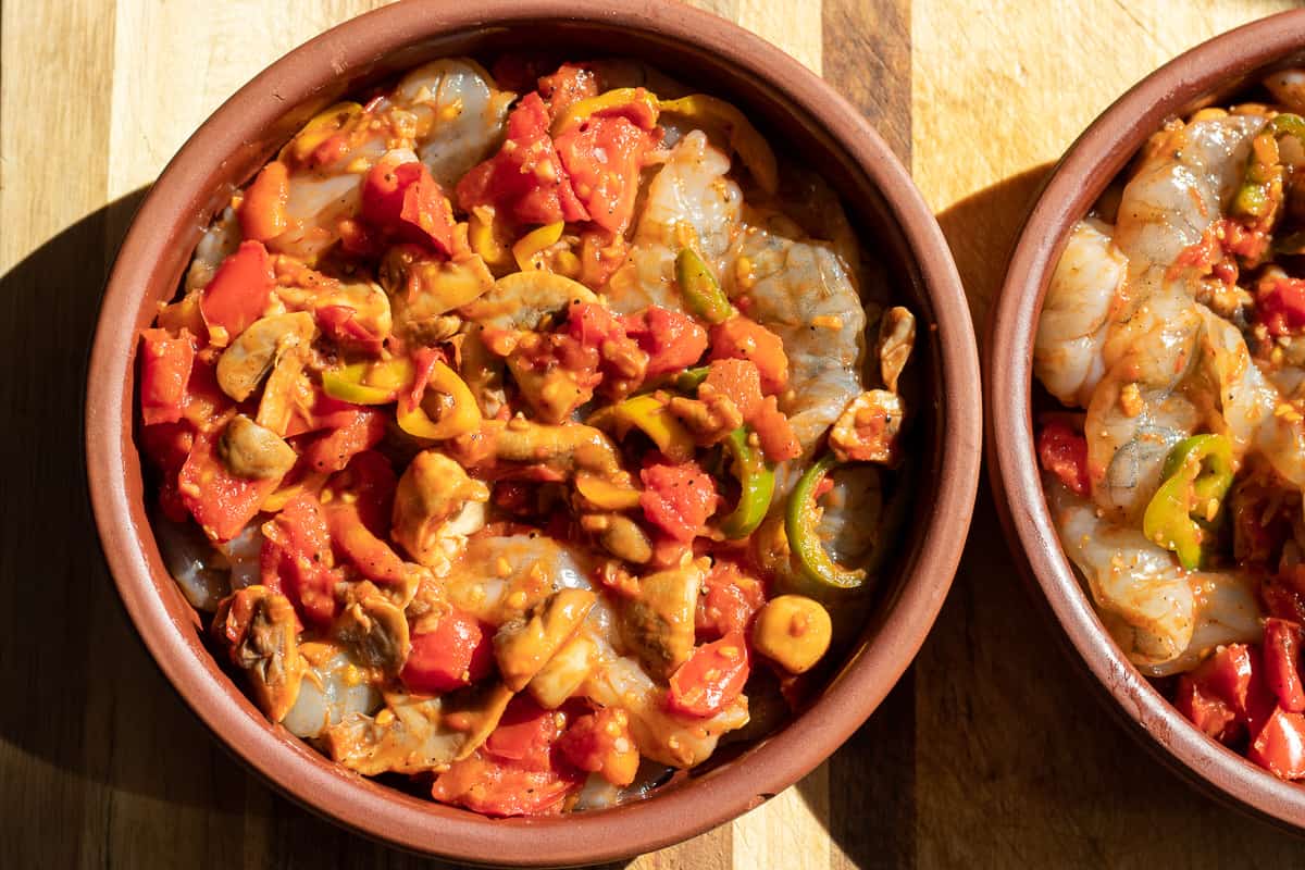 prawns and tomatoey mushroom sauce are placed in an oven dish