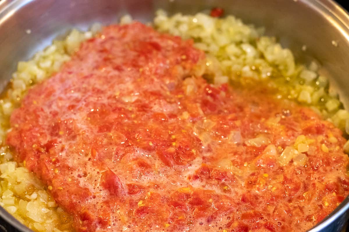 the grated tomatoes are added to sautéed onions