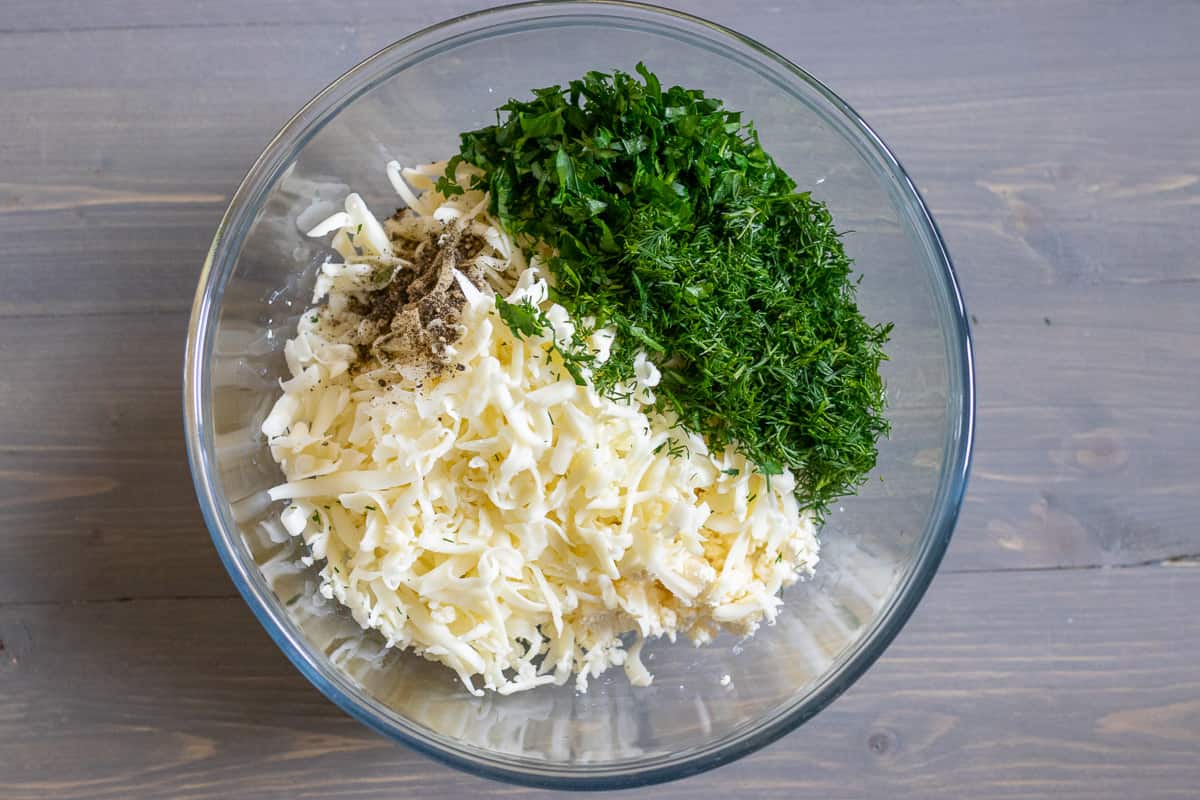 chopped herbs and grated halloumi are added to the bowl