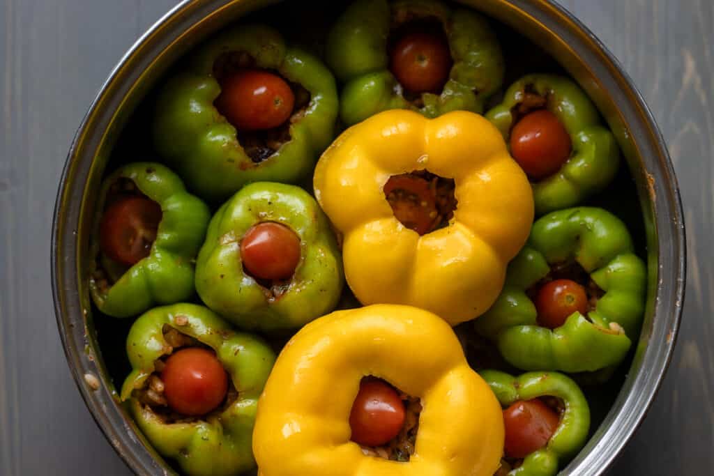 Stuffed peppers are topped with a cherry tomato.