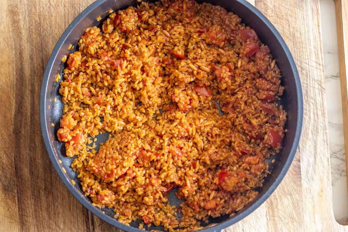 The coarse bulgur is added to the pan.
