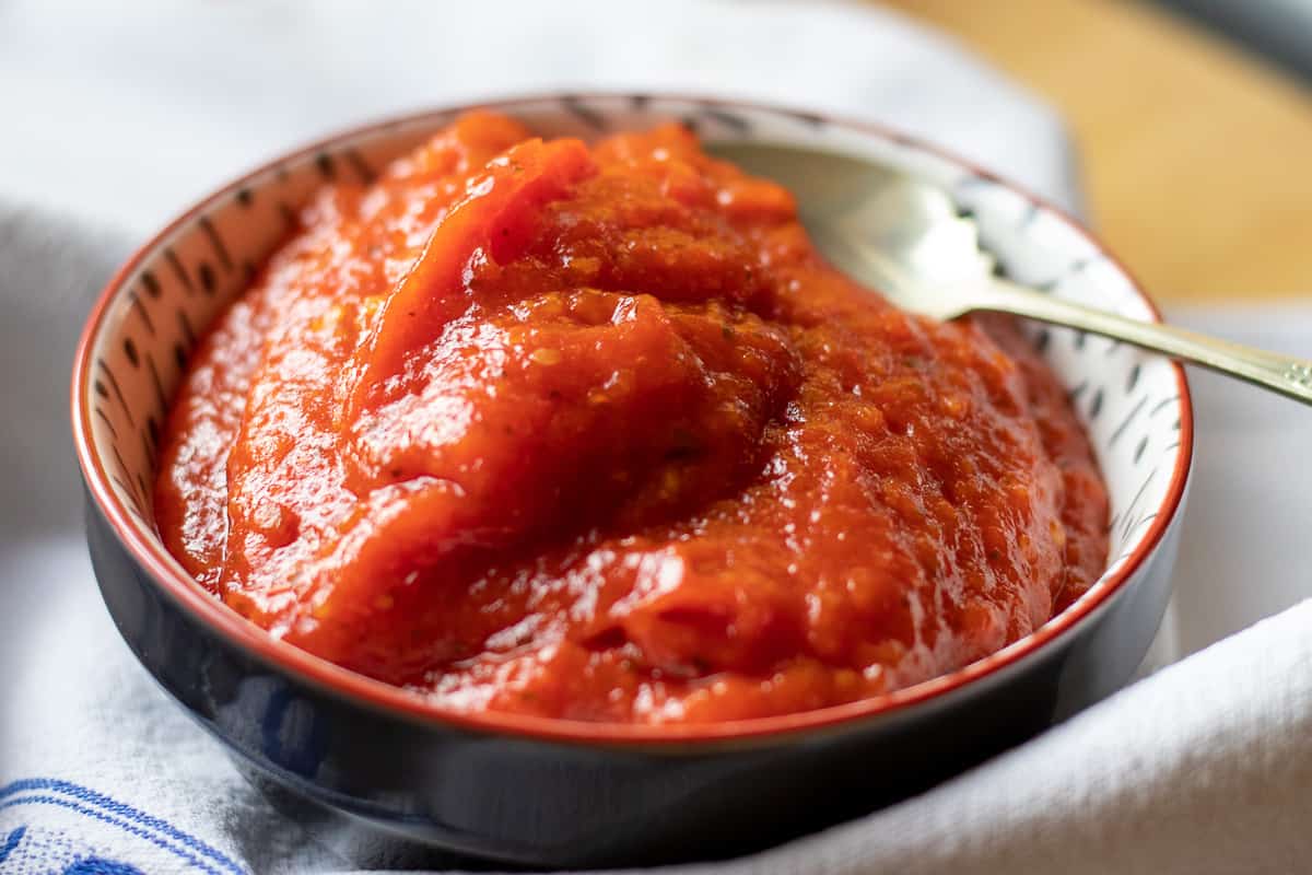 tomato chili jam in a bowl with a spoon