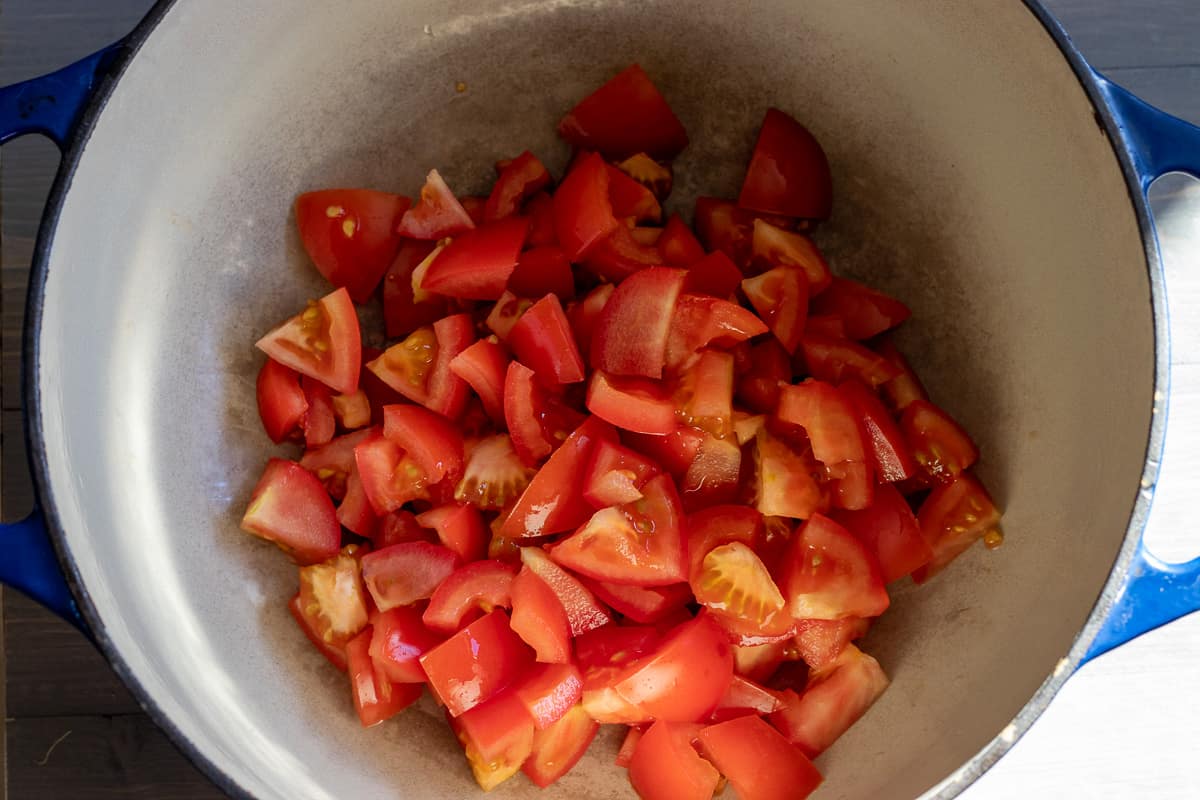 tomatoes are cut and placed in a pan