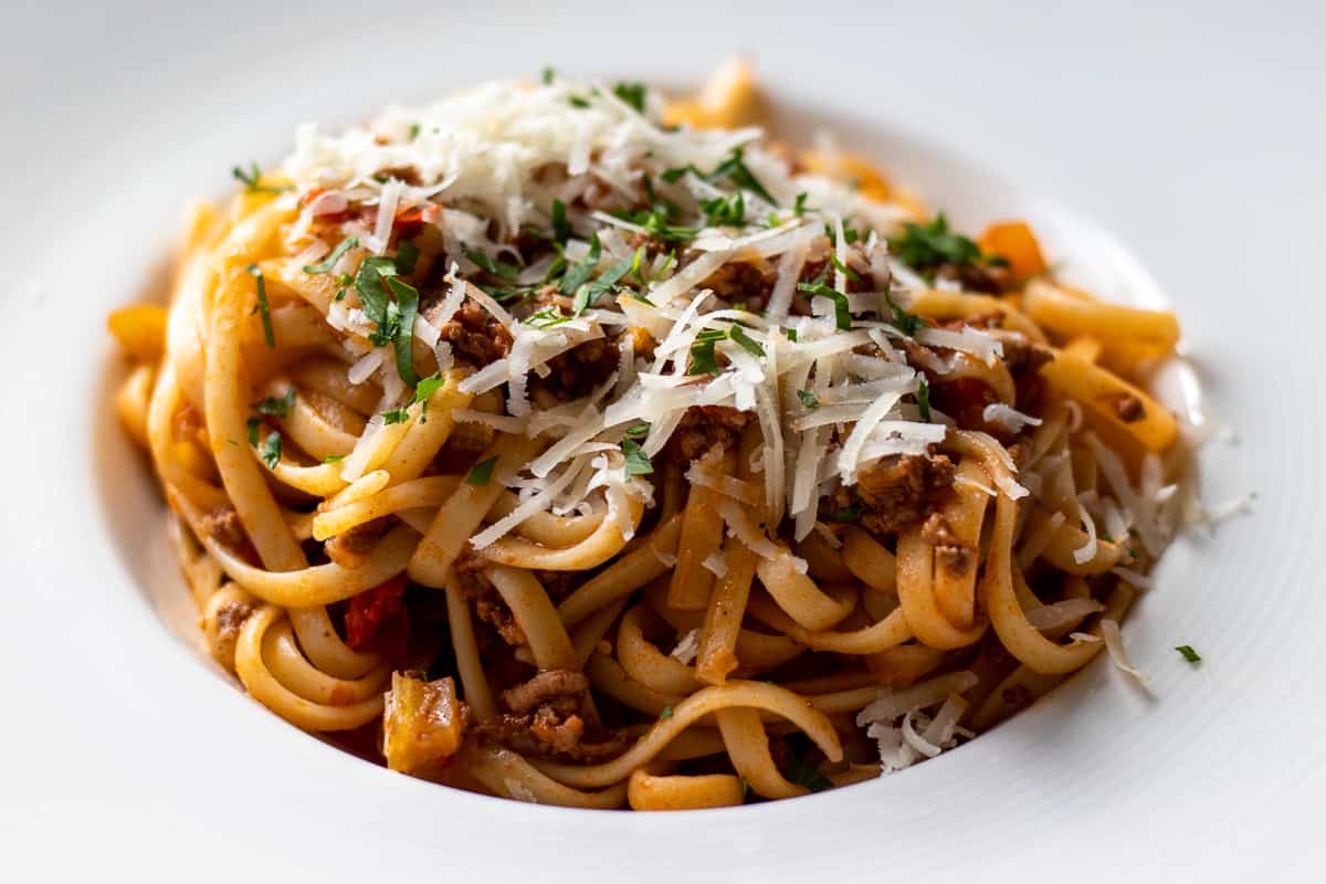 linguine pasta mixed with bolognese sauce and served with grated parmesan