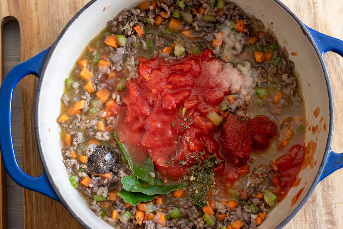 tomatoes, tomato paste, stock and herbs are added to the sauce