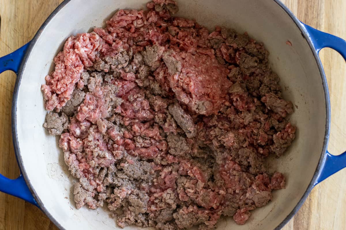 Browning the ground beef in a Dutch oven.