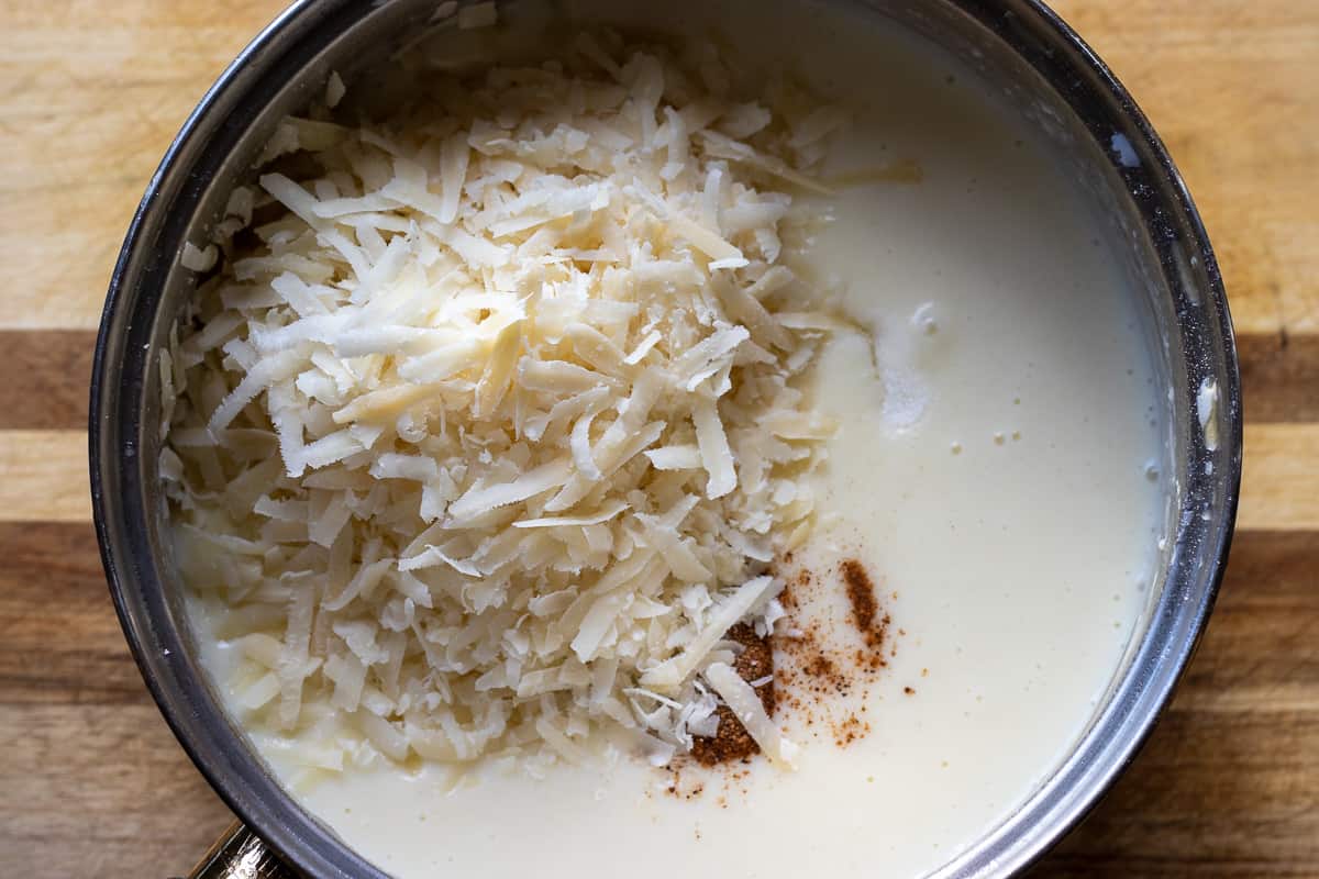 Salt, nutmeg and grated cheese are added to béchamel sauce.