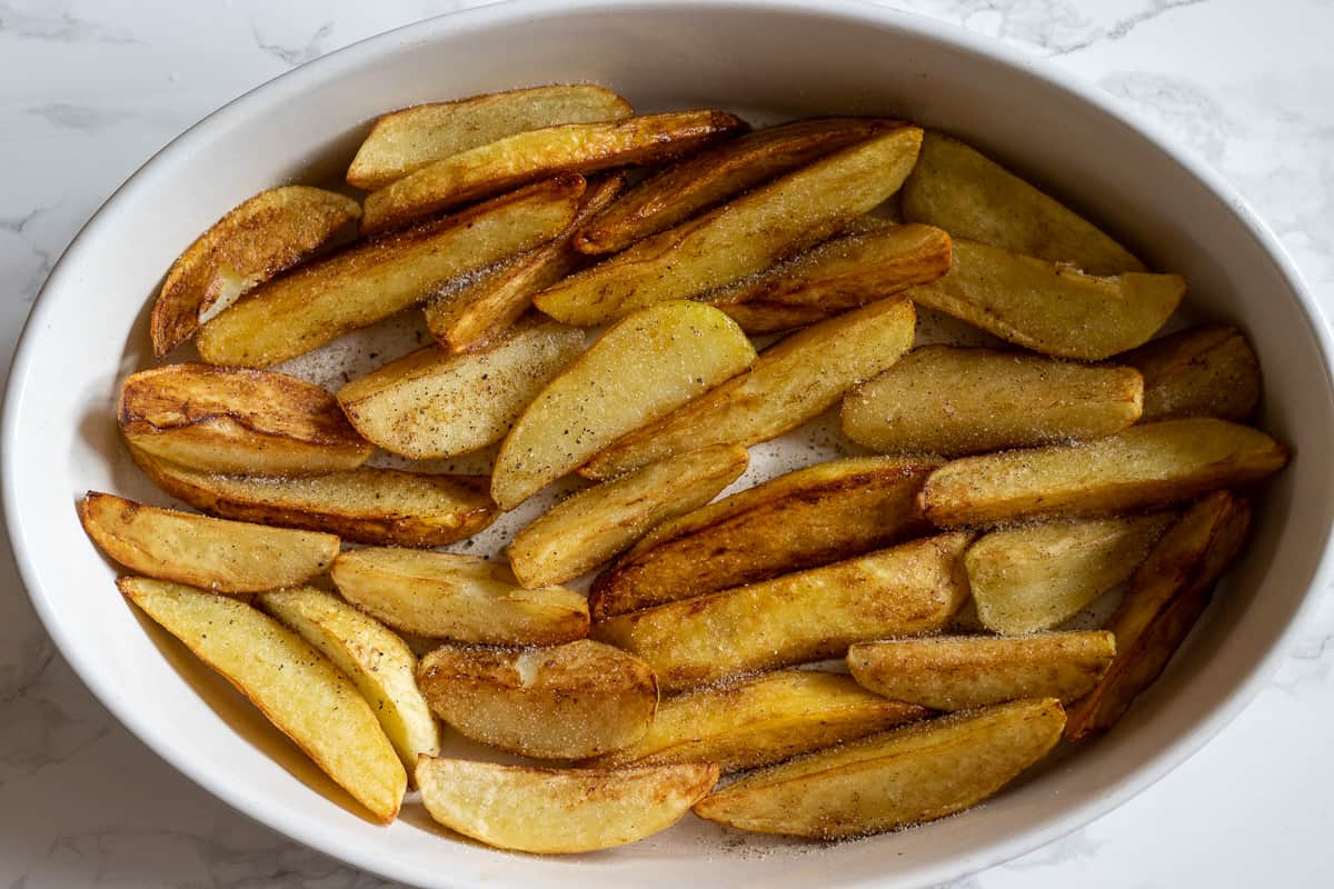 fried potatoes are layered on a baking dish