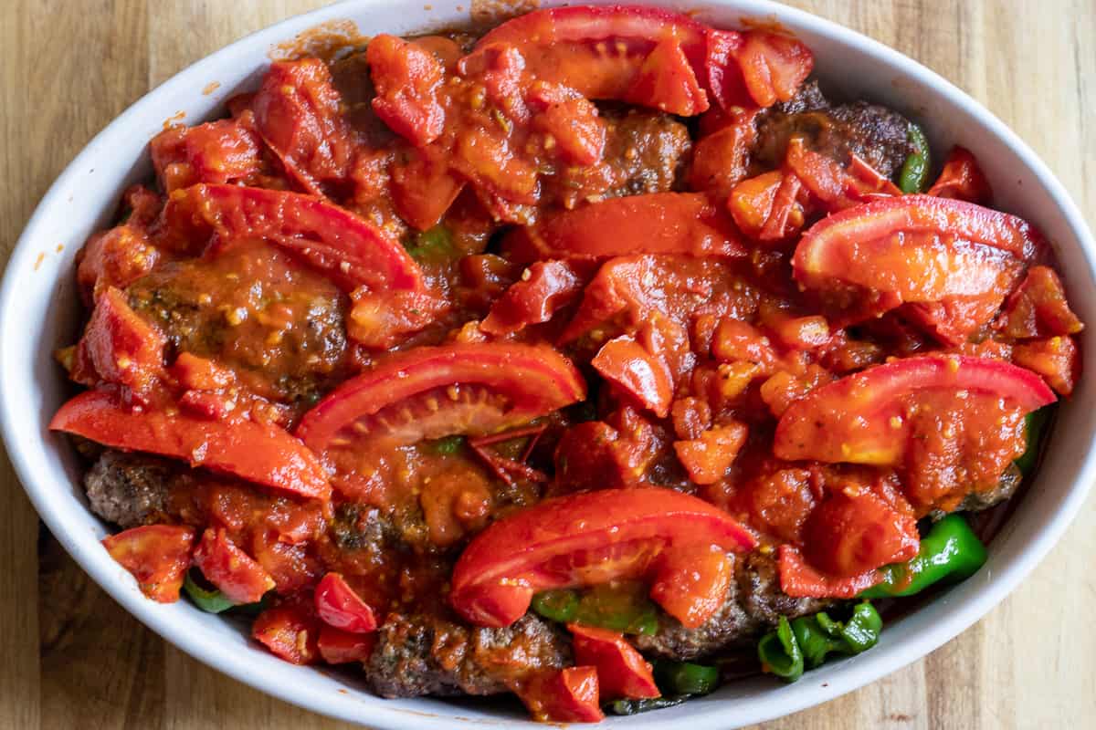 the tomato sauce is poured on meatballs and vegetables