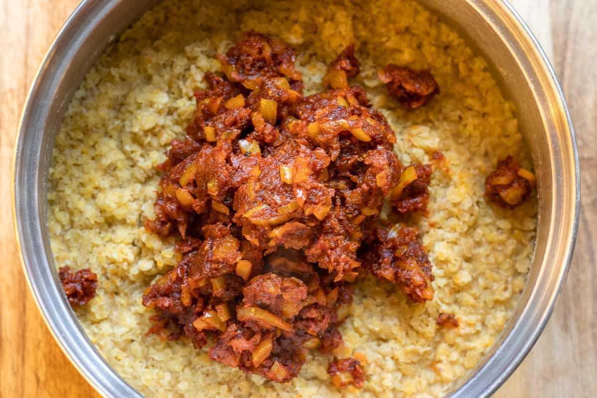 Sautéed onions are added to lentil and bulgur mixture