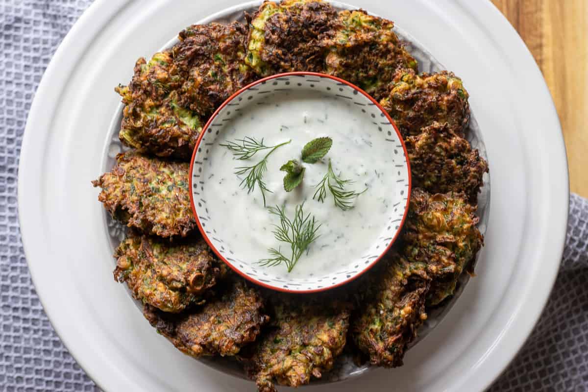 12 pieces of mucver served on a plate with yogurt dip