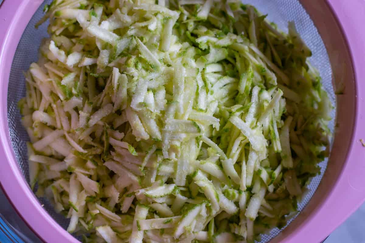 grated zucchini is placed on a colander
