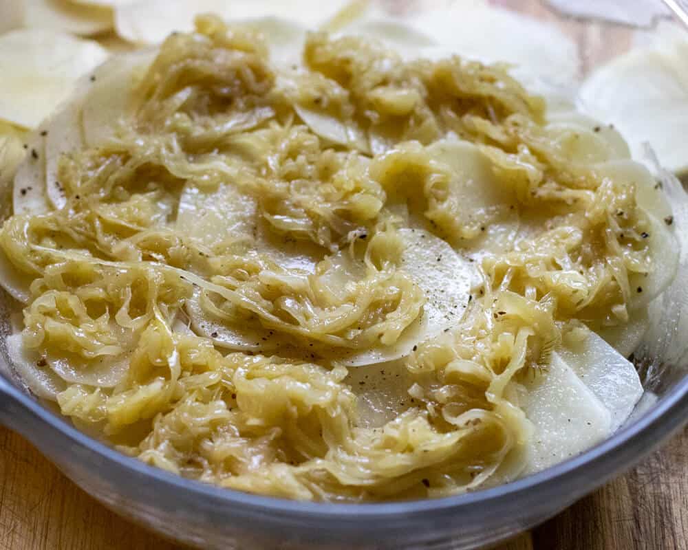 Sautéed onions are layered on potatoes