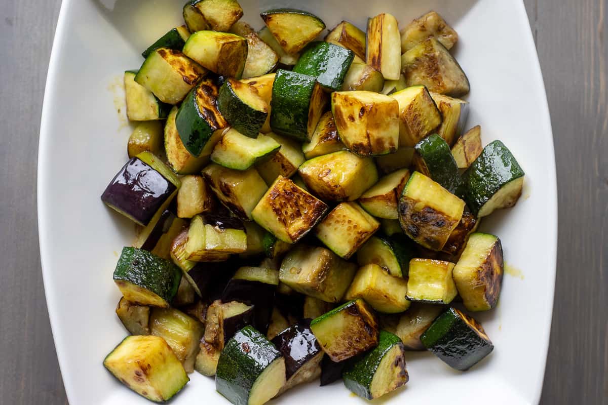 Sautéed zucchinis are placed in a bowl