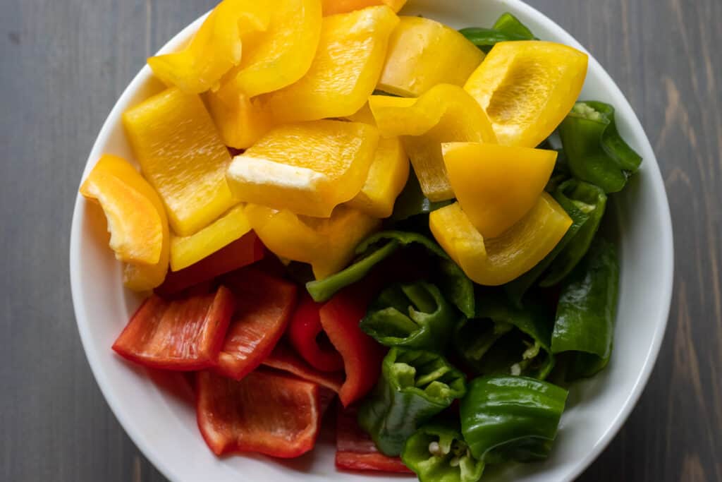 green, yellow and red peppers are cut in cubes